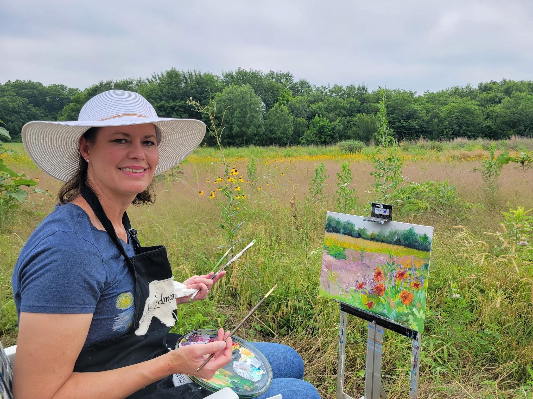 Margaret Edmondson painting outdoors in a wildflower field